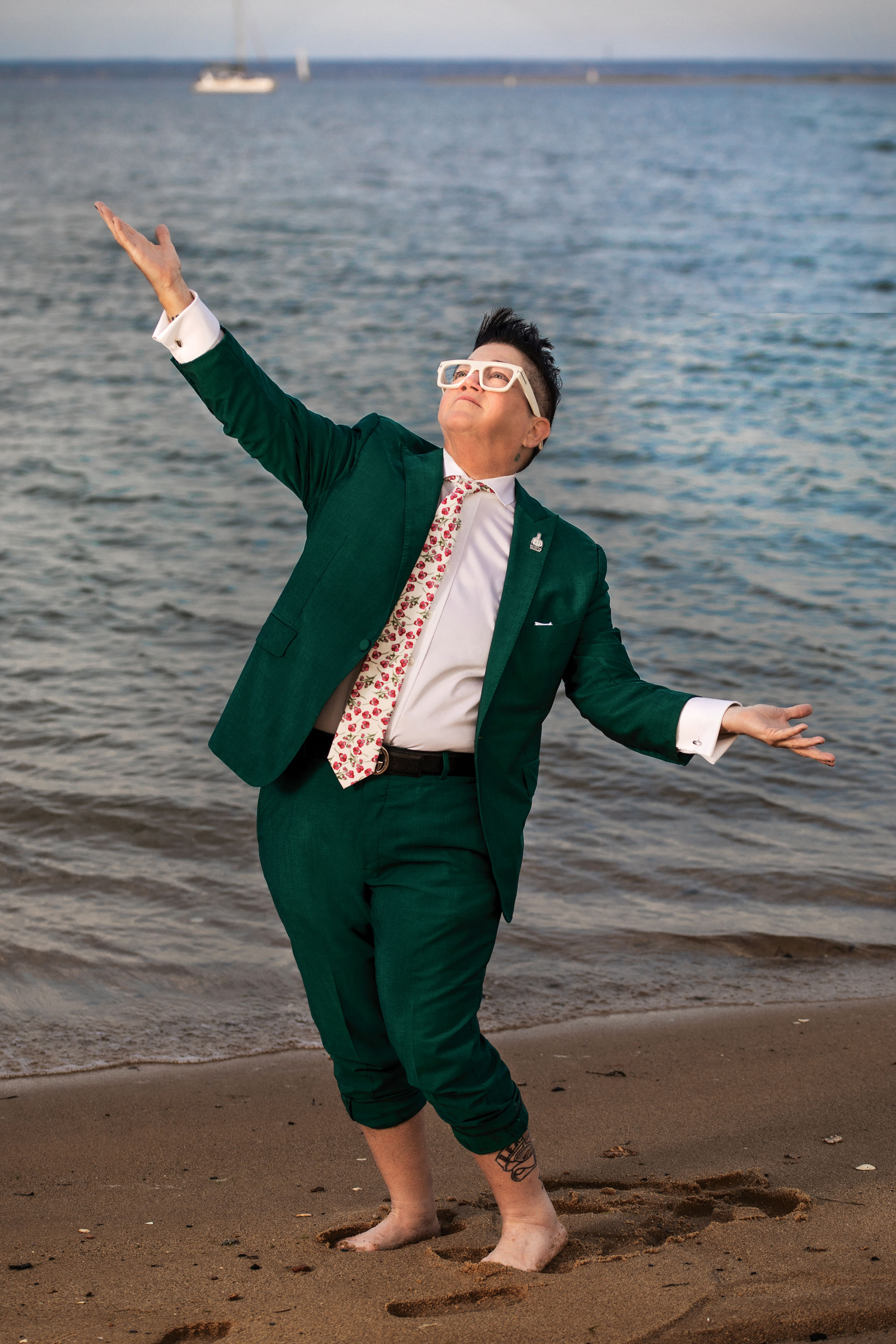 Lea Delaria in a dark suit, white shirt and bright colored tie on the in Provincetown